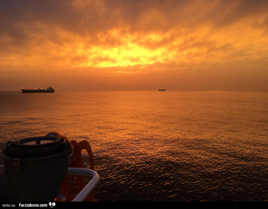 Tramonto in mare in mezzo alle navi