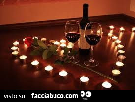 Calici di vino e candele a formare un cuore